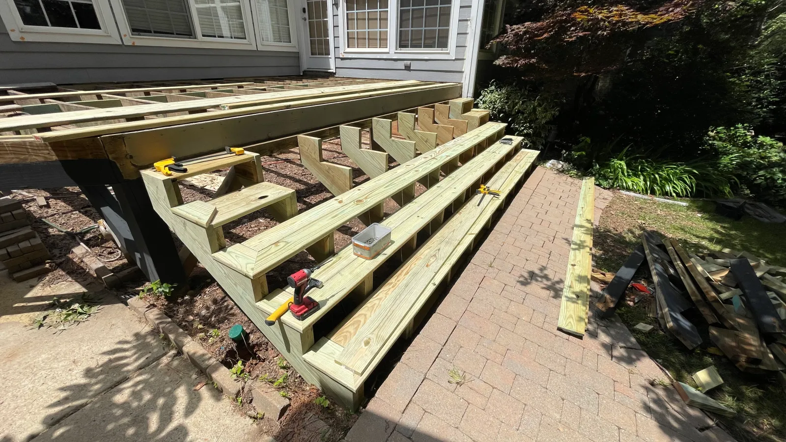 Cut stair stringers set and braced against the deck framing before surfacing