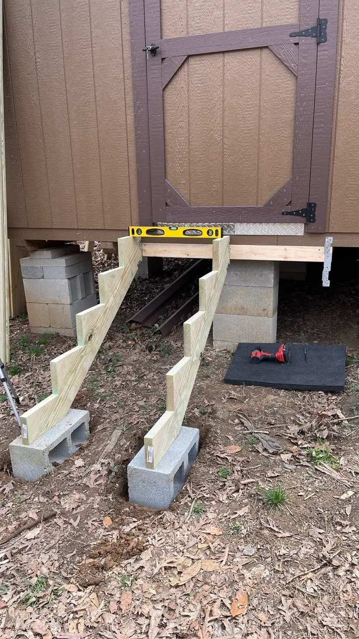 Cut stair stringers set on concrete blocks with a spirit level laid across them