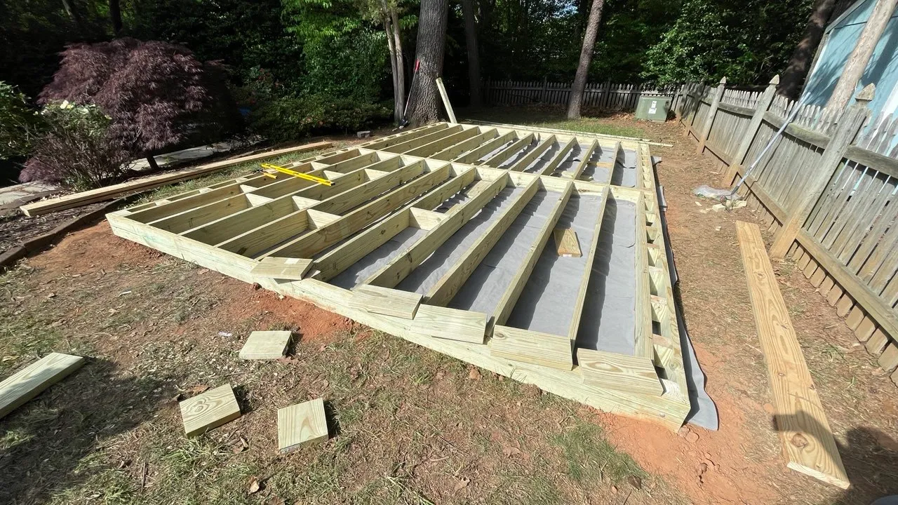 Joist framing over a black ground membrane before the decking is laid