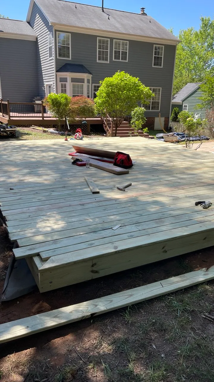 Deck boards part-laid across the joists with tools still on the surface