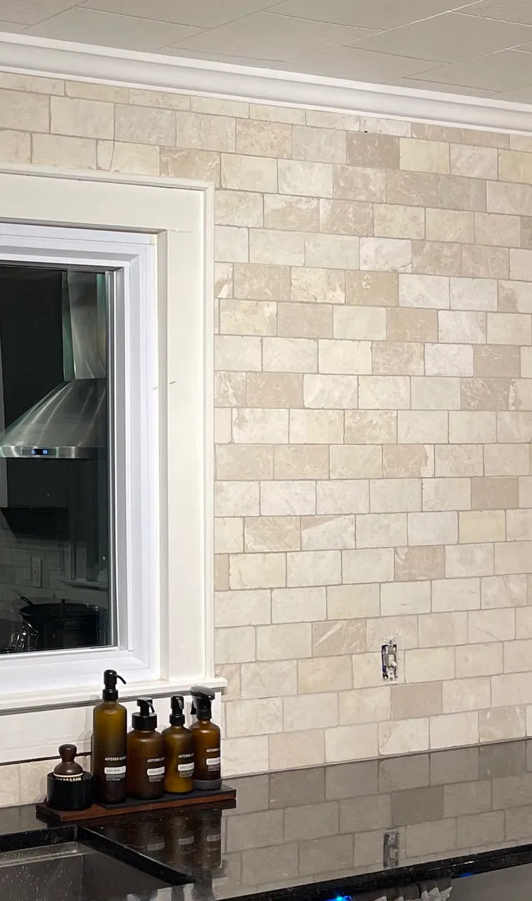 Close view of travertine tile returning into a painted window reveal