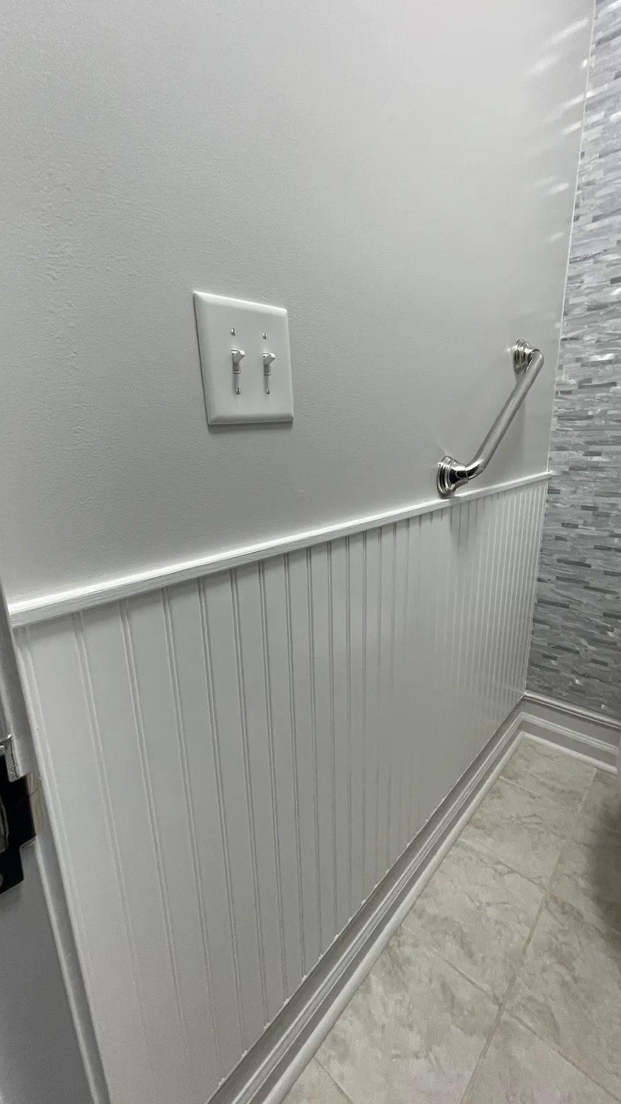 Close view of the beadboard cap meeting the wall and the grab rail fixing