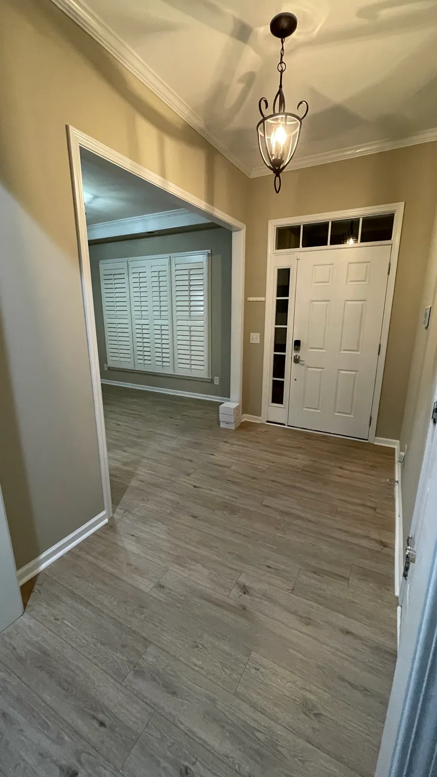 Entry hall with repainted walls, white trim, and wood-look flooring