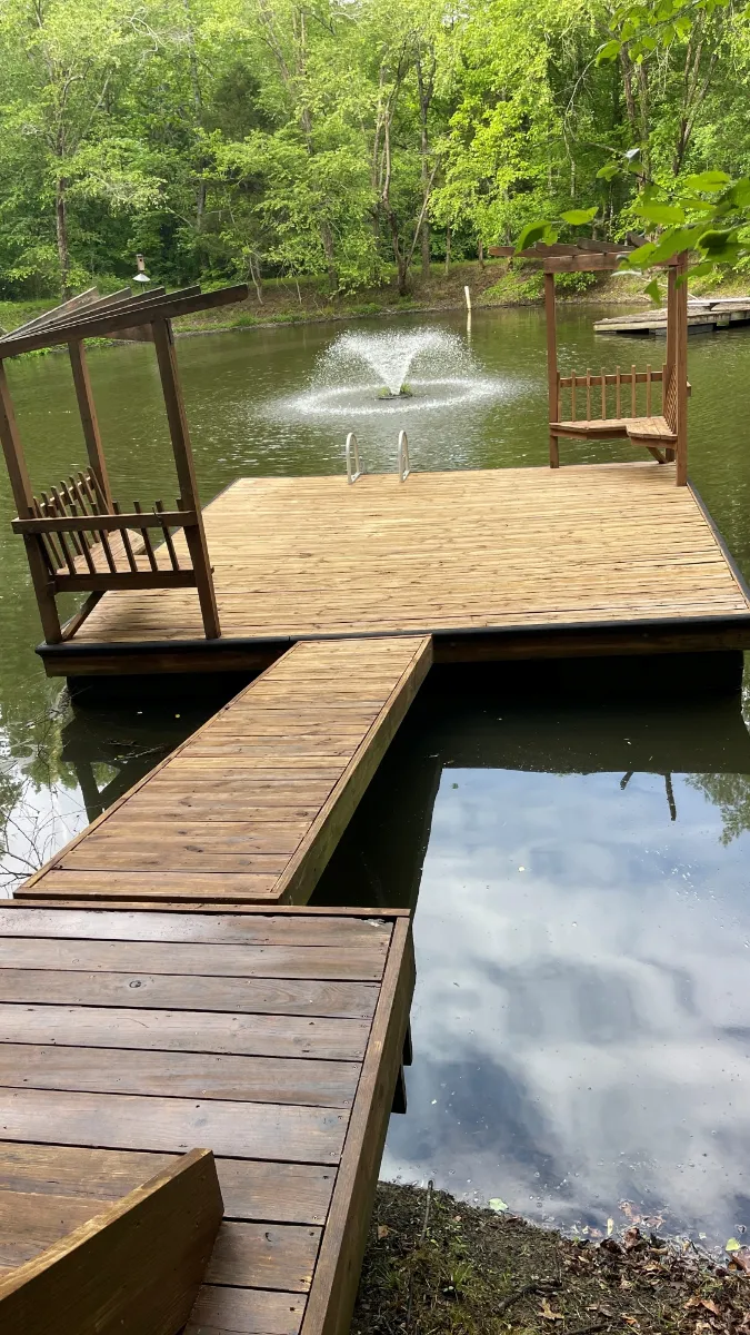 A rebuilt timber dock and walkway running out over a lake to a seating platform