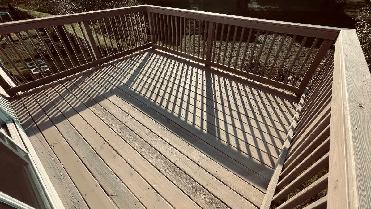 An elevated deck with its boards and rails cleaned back and restained