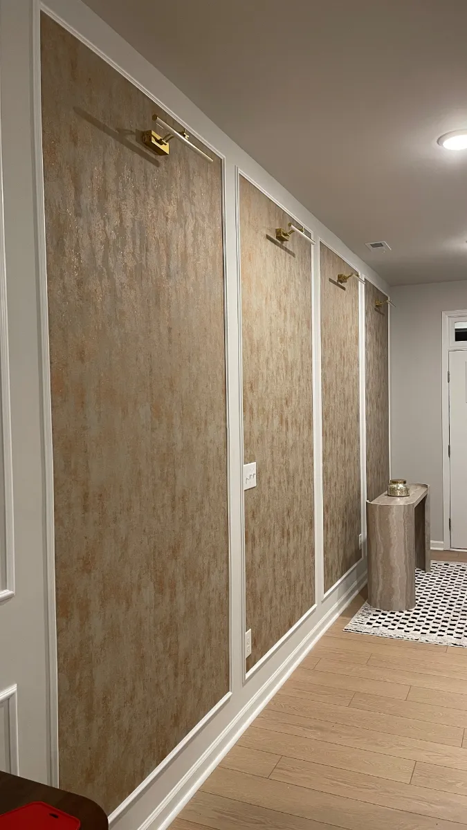 A hallway lined with wood-grain panels between white trim, lit by recessed downlights