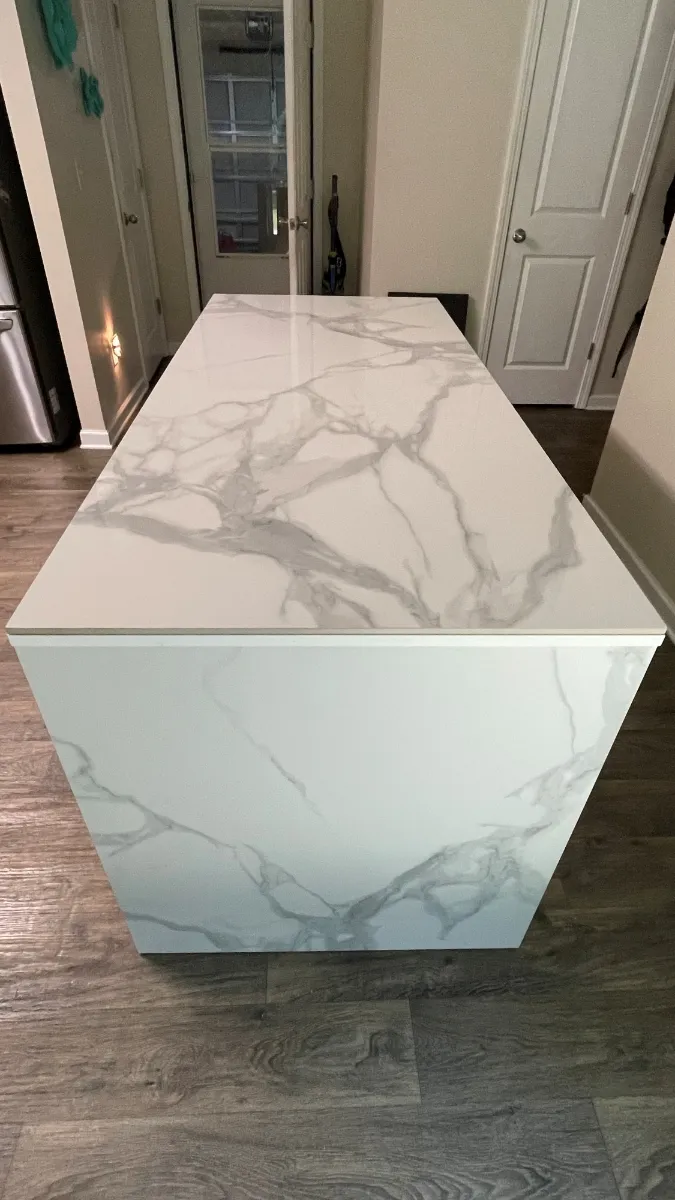The mitred corner where the marble-patterned top folds down the end of the island to the floor