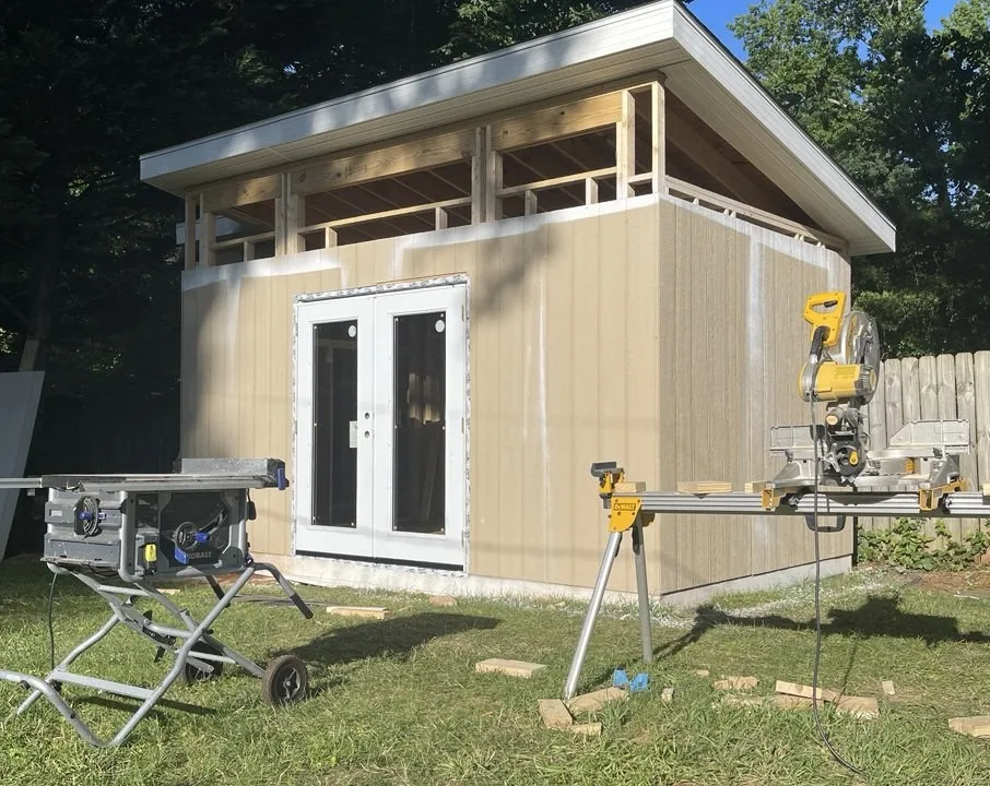 Completed garden studio with clad walls, clerestory windows, and glazed double doors