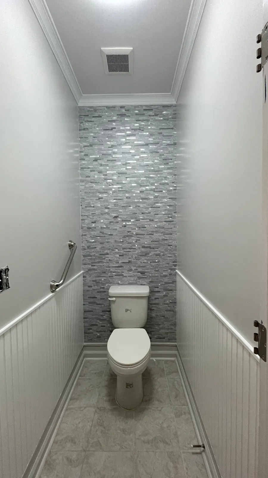 The same room with a stacked stone end wall, white beadboard wainscoting, and a tiled floor